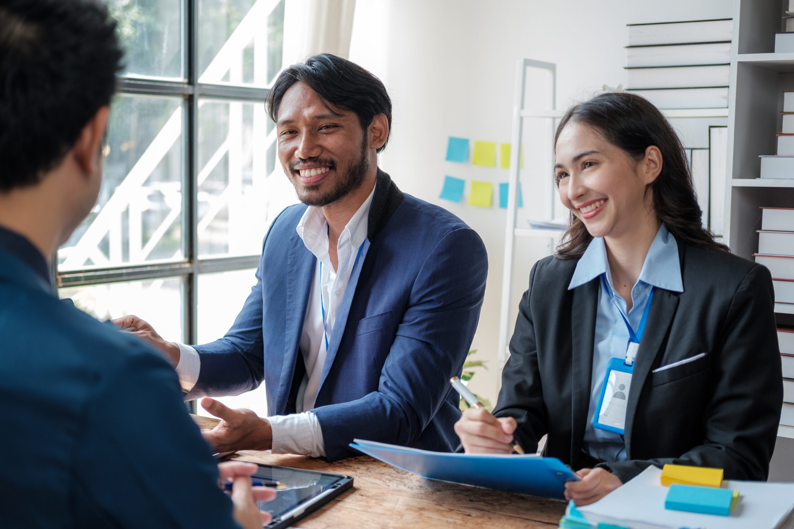 Sales professionals collaborate across a desk.