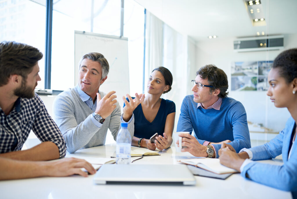 Professionals in a meeting discussing customer acquisition
